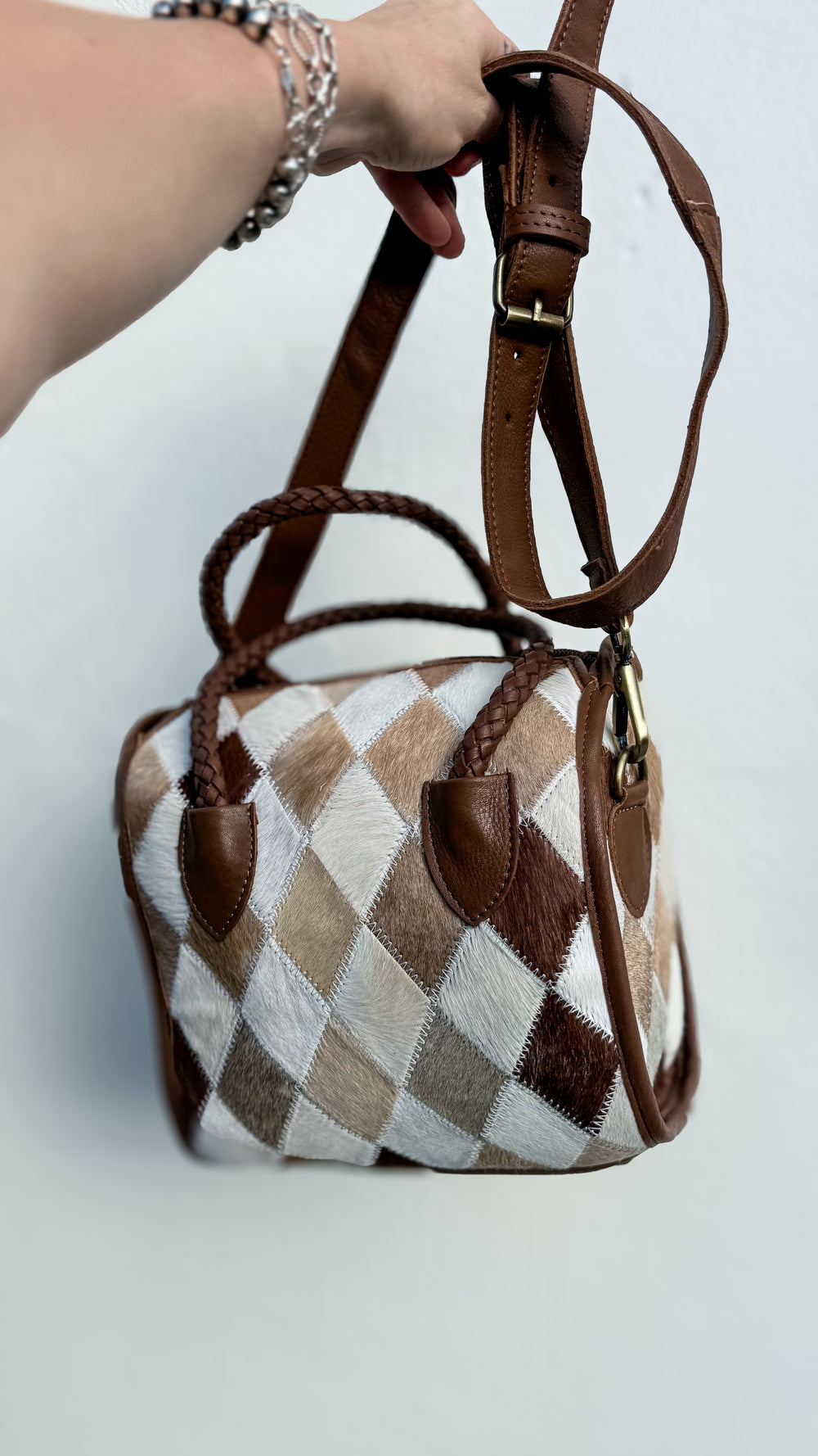 Small diamond patchwork cowhide leather satchel with cream, beige and brown diamond panels, braided handles and detachable strap.